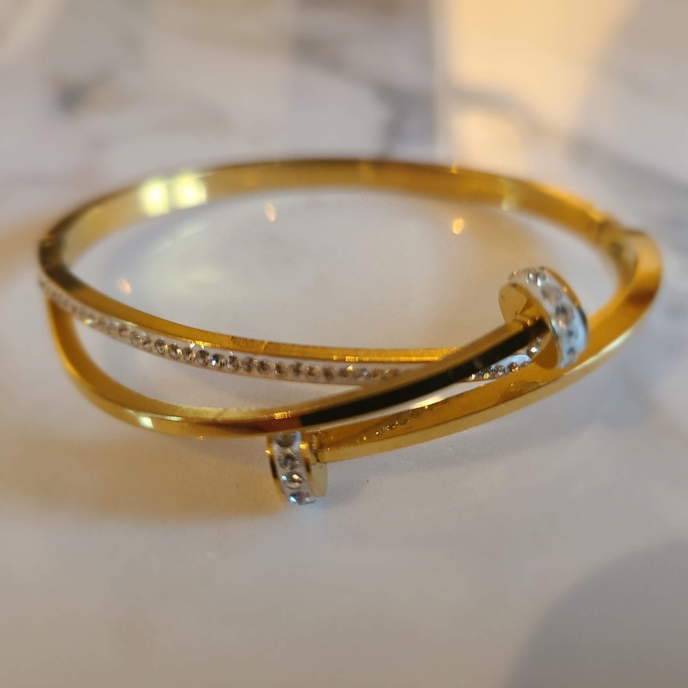 Gold tone bracelet with white accent and CZ.
